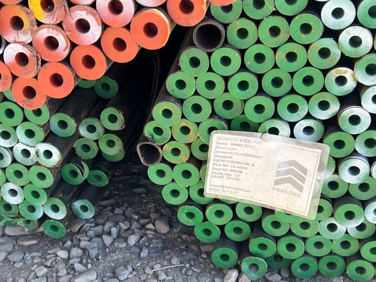 Seamless pipes with green end caps and a Manis Steel tag: 33.4 × 2.8 × 6000 mm, heat 464236, 127 pieces
