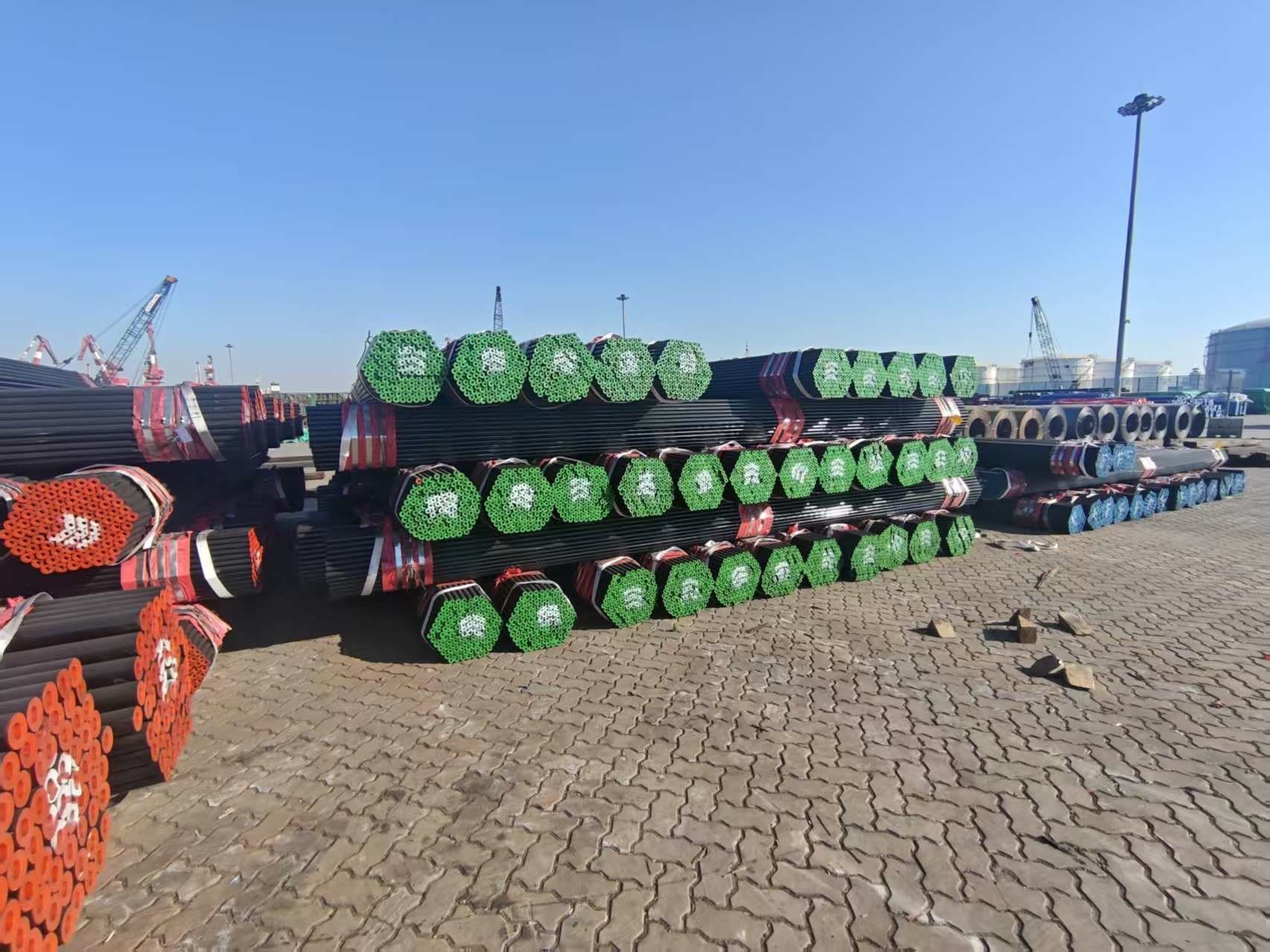 A port stockyard with rows of pipe bundles in green, red and blue end caps