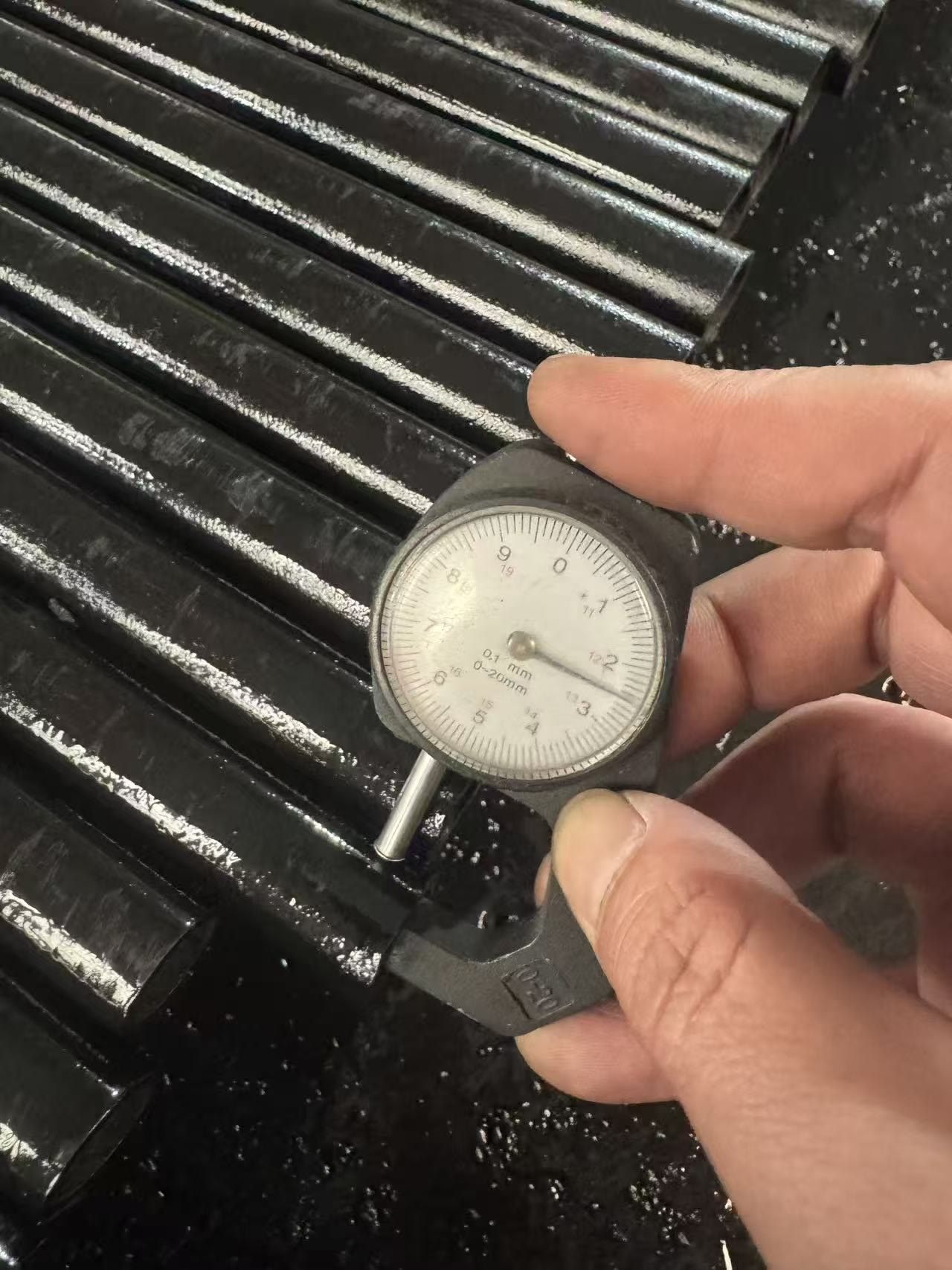 Checking pipe wall thickness with a dial thickness gauge