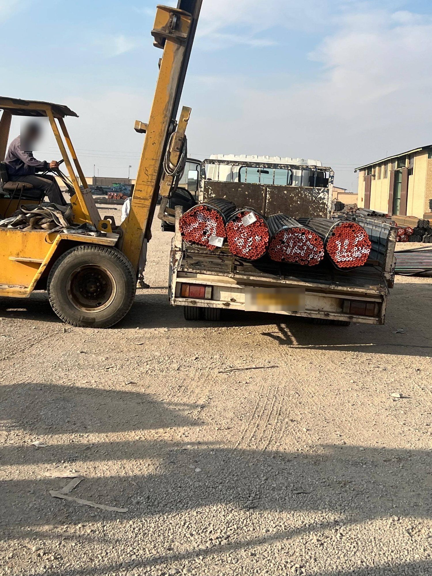 A forklift loading pipe bundles onto a truck in the affiliate’s yard